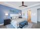 Bright main bedroom featuring a decorative accent wall, king bed, ceiling fan, and light-colored wood flooring at 14718 San Domingo Blvd, Port Charlotte, FL 33981