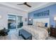 This main bedroom features a ceiling fan, king bed, blue accent wall, and private access to the pool area at 14718 San Domingo Blvd, Port Charlotte, FL 33981