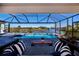 Screened in pool area with cozy seating area and gorgeous water view at 14718 San Domingo Blvd, Port Charlotte, FL 33981