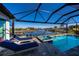 Screened pool with spa, sun loungers and water view on a sunny day at 14718 San Domingo Blvd, Port Charlotte, FL 33981