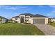 Beautiful home featuring a well-manicured lawn, paver driveway, and neutral color palette at 15044 Acorn Cir, Port Charlotte, FL 33981