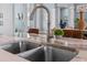Close-up of kitchen sink with granite countertops and open view to the living area at 15044 Acorn Cir, Port Charlotte, FL 33981