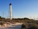 Scenic view of a white metal lighthouse standing tall on a sandy beach with coastal vegetation at 15044 Acorn Cir, Port Charlotte, FL 33981