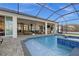 Screened-in pool area with tile trim, outdoor seating, and dining space at 15044 Acorn Cir, Port Charlotte, FL 33981