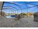 Screened in lanai showcases a pool, spa, outdoor lounge area and outdoor kitchen with waterfront views at 15044 Acorn Cir, Port Charlotte, FL 33981