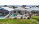 Aerial view of home with a pool and screened-in lanai, surrounded by lush landscaping and neighboring homes at 16 Windward Ter, Placida, FL 33946