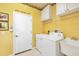Bright laundry room with washer, dryer, utility sink, and overhead cabinets at 16 Windward Ter, Placida, FL 33946