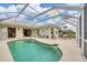 Screened-in patio with large kidney-shaped pool, surrounded by green lawns and golf course views at 16 Windward Ter, Placida, FL 33946