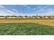 Backyard featuring a large grassy field and partial view of houses at 1602 Saddlewood Cir, Port Charlotte, FL 33953