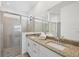 Bathroom with a double sink vanity, granite countertop, tiled shower, and glass door at 1602 Saddlewood Cir, Port Charlotte, FL 33953
