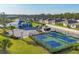 Aerial view of community pickleball courts and clubhouse with lush landscaping at 1602 Saddlewood Cir, Port Charlotte, FL 33953