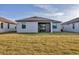 Rear exterior of a modern one-story home with a screened-in porch at 1602 Saddlewood Cir, Port Charlotte, FL 33953