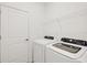 Laundry room with white washer and dryer and wire shelving at 1602 Saddlewood Cir, Port Charlotte, FL 33953