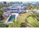 Breathtaking aerial view showcasing the home, pool, putting green, and lush landscaping at 16250 Sunset Pines Cir, Boca Grande, FL 33921