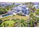 Stunning coastal home featuring a pool, putting green, and beach access amidst lush palm trees at 16250 Sunset Pines Cir, Boca Grande, FL 33921