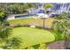 Aerial view of a backyard with putting green, pool, deck, and a lush tropical landscape at 16250 Sunset Pines Cir, Boca Grande, FL 33921