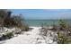 Secluded beach view surrounded by natural vegetation and glistening ocean waters at 16250 Sunset Pines Cir, Boca Grande, FL 33921