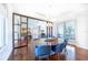 Bright dining room with wood floors, modern lighting, and stylish blue chairs at 16250 Sunset Pines Cir, Boca Grande, FL 33921