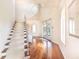 Grand foyer with staircase, modern chandelier, hardwood floors, and bright natural light at 16250 Sunset Pines Cir, Boca Grande, FL 33921