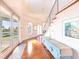 Light-filled foyer featuring hardwood floors, a staircase with metal railing, and a decorative table at 16250 Sunset Pines Cir, Boca Grande, FL 33921