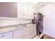 Laundry room with a stainless steel stacked washer and dryer and plenty of cabinets at 16250 Sunset Pines Cir, Boca Grande, FL 33921