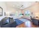 Living room featuring wood floors, a ceiling fan, a black couch and a desk at 16250 Sunset Pines Cir, Boca Grande, FL 33921