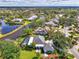 A peaceful home is captured from above with a screened pool and water views, surrounded by lush landscaping at 17 Dominica Dr, Englewood, FL 34223