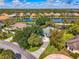 An elevated view reveals a home with meticulous landscaping, a charming blue shutter accent, and a picturesque community lake at 17 Dominica Dr, Englewood, FL 34223