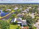 A peaceful home is captured from above with a screened pool and water views, surrounded by lush landscaping at 17 Dominica Dr, Englewood, FL 34223