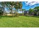 Expansive backyard with lush green lawn and screened-in lanai, ideal for outdoor activities and relaxation at 17 Dominica Dr, Englewood, FL 34223