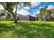 Lush green backyard featuring a screened-in lanai, offering privacy and space for outdoor enjoyment at 17 Dominica Dr, Englewood, FL 34223