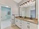 Bathroom featuring double vanity with granite counters, modern lighting, and access to the laundry area at 17 Dominica Dr, Englewood, FL 34223