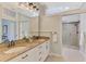 Modern bathroom featuring granite counters, dual sinks, large mirrors, and a glass-enclosed shower at 17 Dominica Dr, Englewood, FL 34223