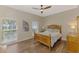 Cozy bedroom with hardwood floors, two windows, ceiling fan, and a wooden bed with decorative bedding at 17 Dominica Dr, Englewood, FL 34223