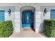 Elegant blue front door framed by white columns and lush greenery at 17 Dominica Dr, Englewood, FL 34223