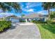 Charming single-story home with a long driveway, blue shutters, manicured lawn, and beautiful landscaping at 17 Dominica Dr, Englewood, FL 34223
