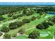 Scenic aerial view of lush golf course, with winding fairways, mature trees, and water hazards at 17 Dominica Dr, Englewood, FL 34223