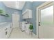 Well-lit laundry room with white cabinetry, marble countertops, stainless steel sink, washer, and dryer at 17 Dominica Dr, Englewood, FL 34223