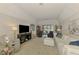 Bright living room featuring a white couch and black recliners adjacent to sliding glass doors to the outdoor pool at 17 Dominica Dr, Englewood, FL 34223