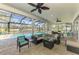 Screened patio with comfortable wicker seating around a table and view of the pool and pond at 17 Dominica Dr, Englewood, FL 34223