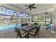 Screened lanai offering a dining area and views of the pool and scenic backyard at 17 Dominica Dr, Englewood, FL 34223