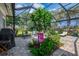 Serene screened lanai with outdoor seating, lush plants, and view of the backyard at 17 Dominica Dr, Englewood, FL 34223