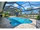 Sparkling screened-in pool with brick trim, lush landscaping and sun loungers for ultimate relaxation at 17 Dominica Dr, Englewood, FL 34223
