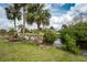 Spacious backyard with manicured lawn, palm trees, waterfront access, and wooden dock, ideal for outdoor enjoyment at 184 Eppinger Dr, Port Charlotte, FL 33953