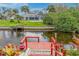 A private wooden dock, complete with access steps and decorative lamps, extends onto a canal in this inviting waterfront setting at 184 Eppinger Dr, Port Charlotte, FL 33953