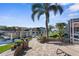 Waterfront backyard with brick patio, seating, and lush tropical landscaping at 2160 Palm Tree Dr, Punta Gorda, FL 33950