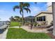Well-manicured backyard with waterfront view, dock, and brick patio at 2160 Palm Tree Dr, Punta Gorda, FL 33950