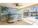 Wet bar in the lanai with tropical mural and seating adds a touch of whimsy at 2160 Palm Tree Dr, Punta Gorda, FL 33950
