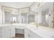 Bright bathroom with white cabinets, countertop, gold hardware, and large mirrors at 2160 Palm Tree Dr, Punta Gorda, FL 33950
