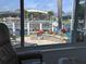 A sunroom view showcasing a modern boat lift and dock on the canal, surrounded by beautiful landscaping at 2160 Palm Tree Dr, Punta Gorda, FL 33950